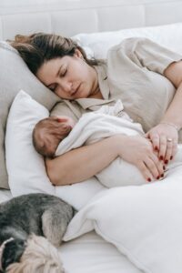 mother asleep with baby in her arms