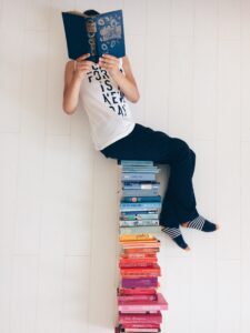 person sitting on stack of books