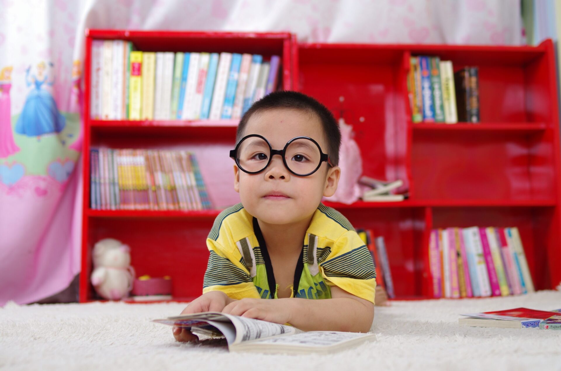 boy reading in front of bookshelf