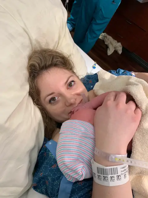 mom in hospital bed holding newborn