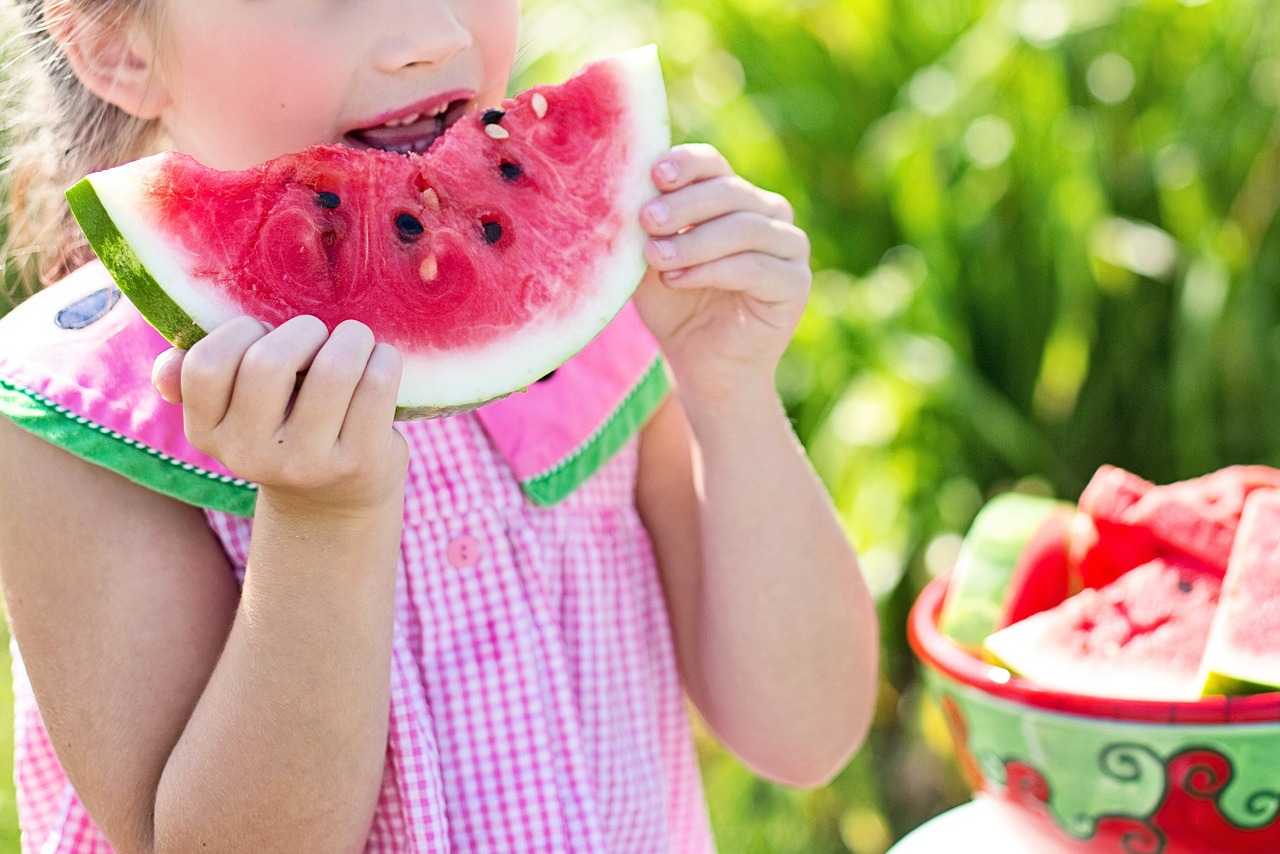 girl eating watermelon outside