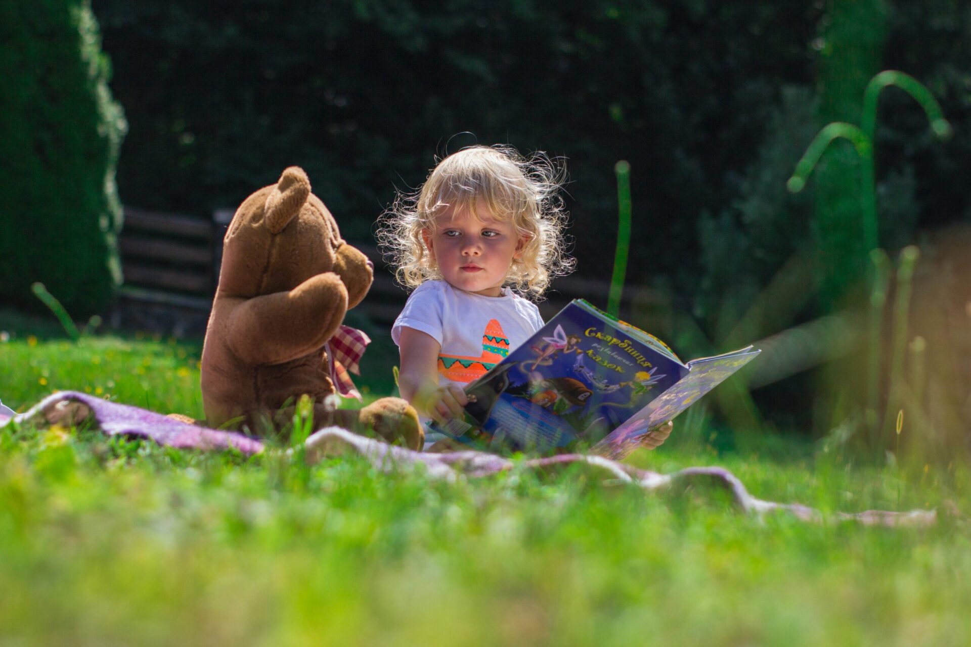 child reading book with bear